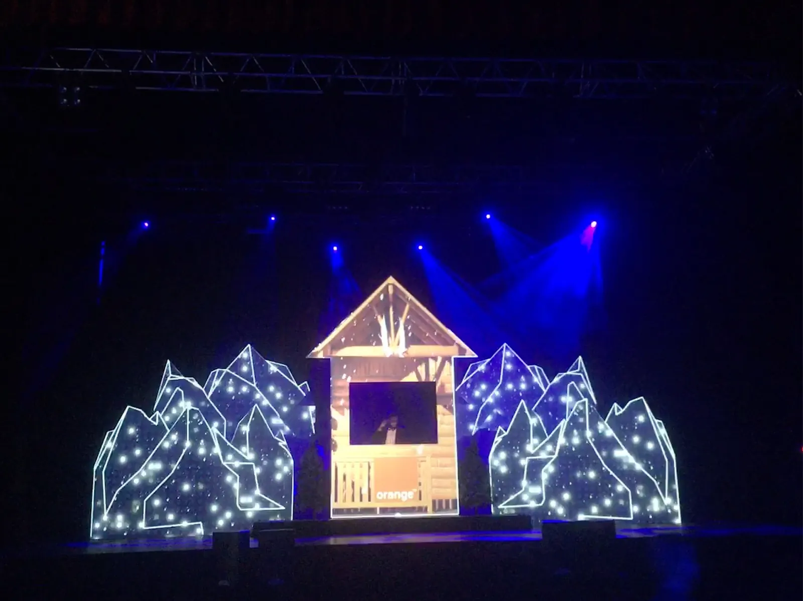 Décor de chalet lumineux sur scène pour la soirée Orange