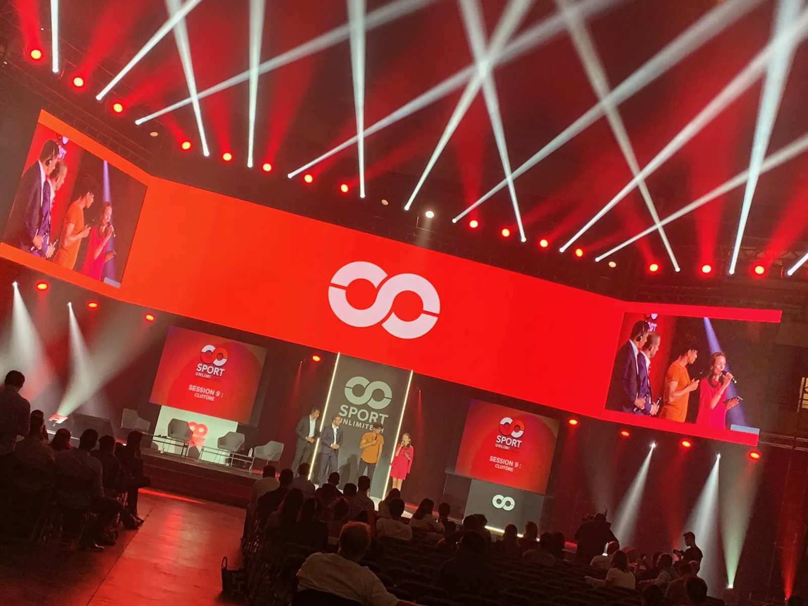 Plénière Sport Unlimitech, écrans et faisceaux lumineux rouges